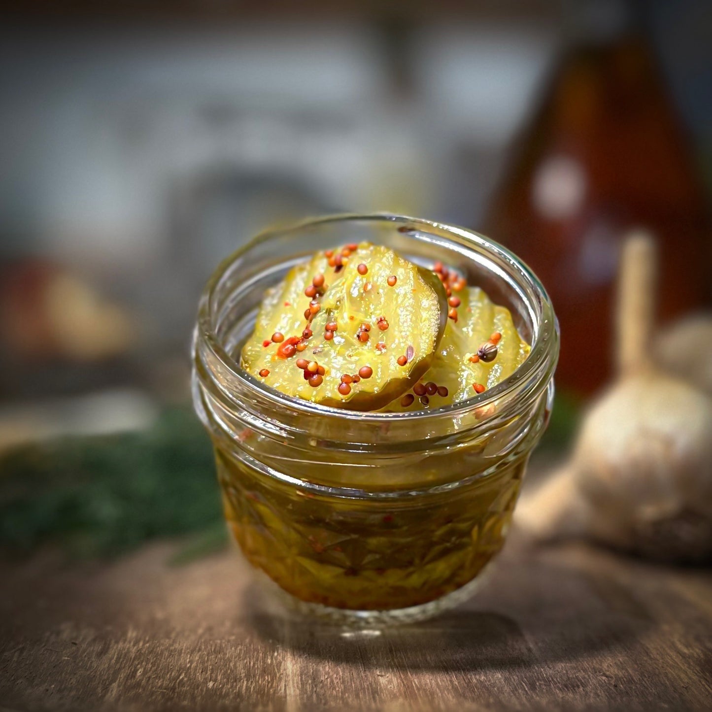 Jar of pickles with spices on a wooden surface