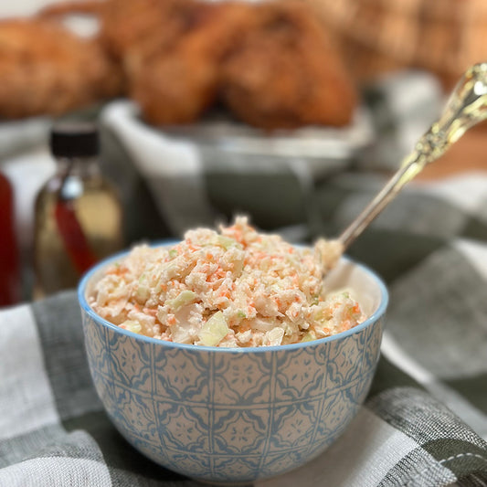 Bowl of coleslaw with a spoon, blurred background